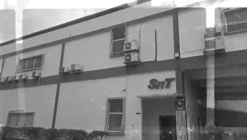 The original SNT Global Logistics office sign on the first building.